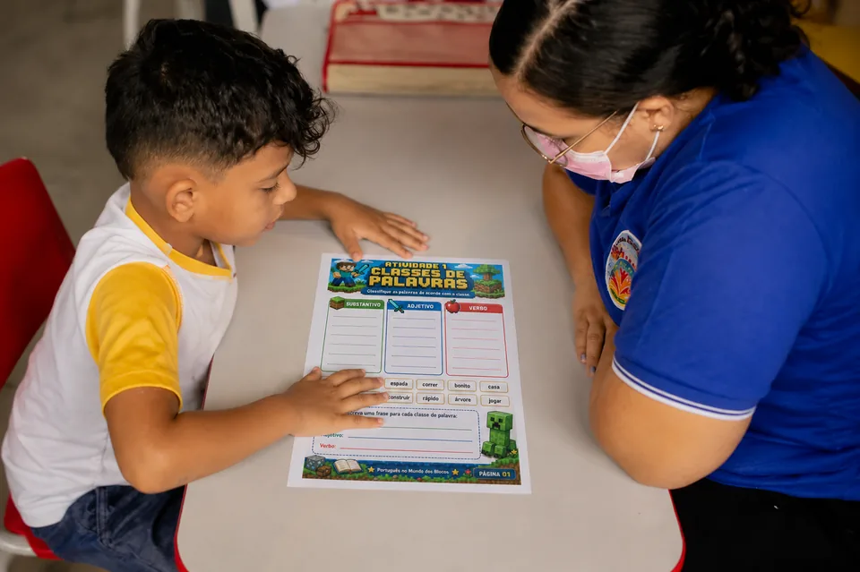 Crianca estudando portugues com professora usando o material